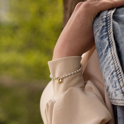 Model wearing sterling silver and gold padlock and key bracelet