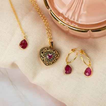 collection of jewellery with ruby gemstones on a piece of fabric