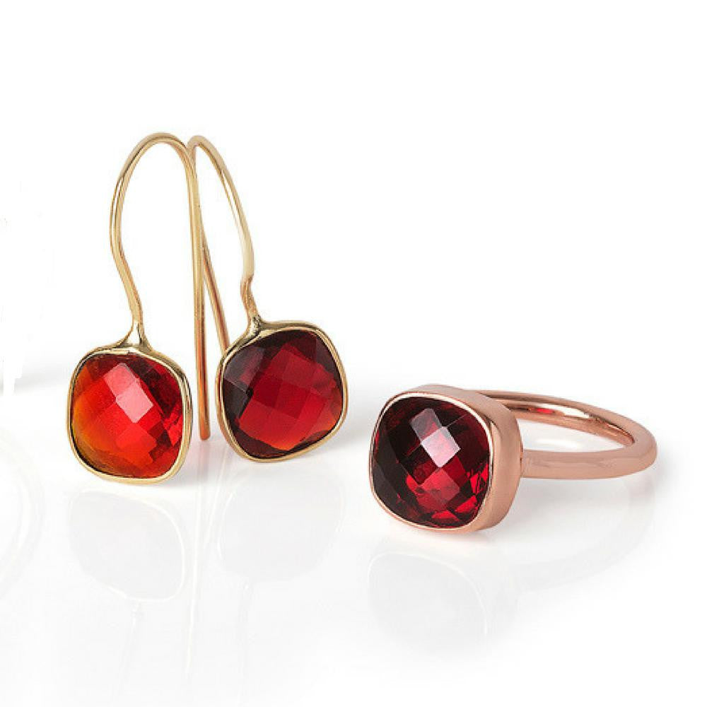 garnet cocktail ring and earrings on a white background