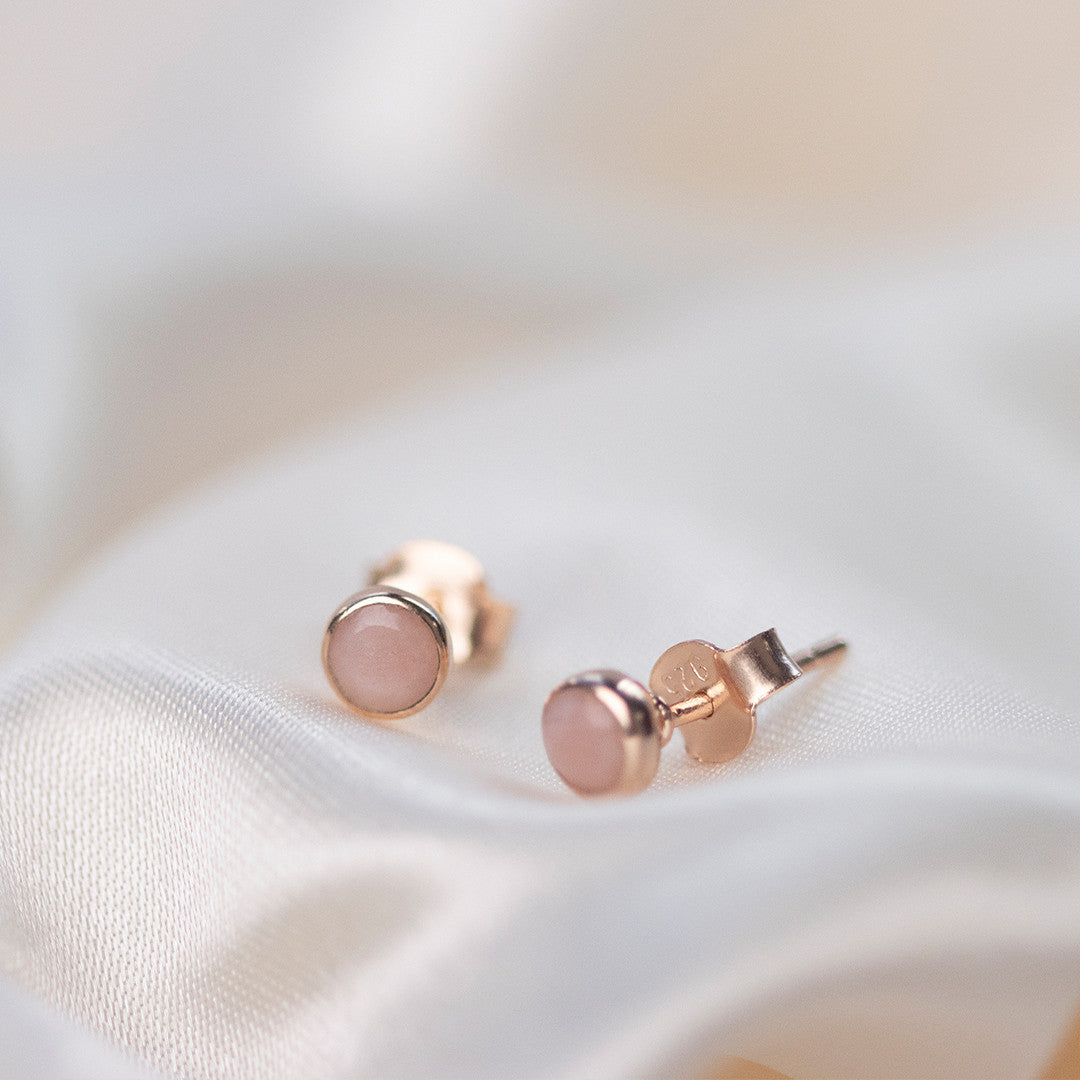 pink opal mini stud earrings in rose gold on a white piece of fabric