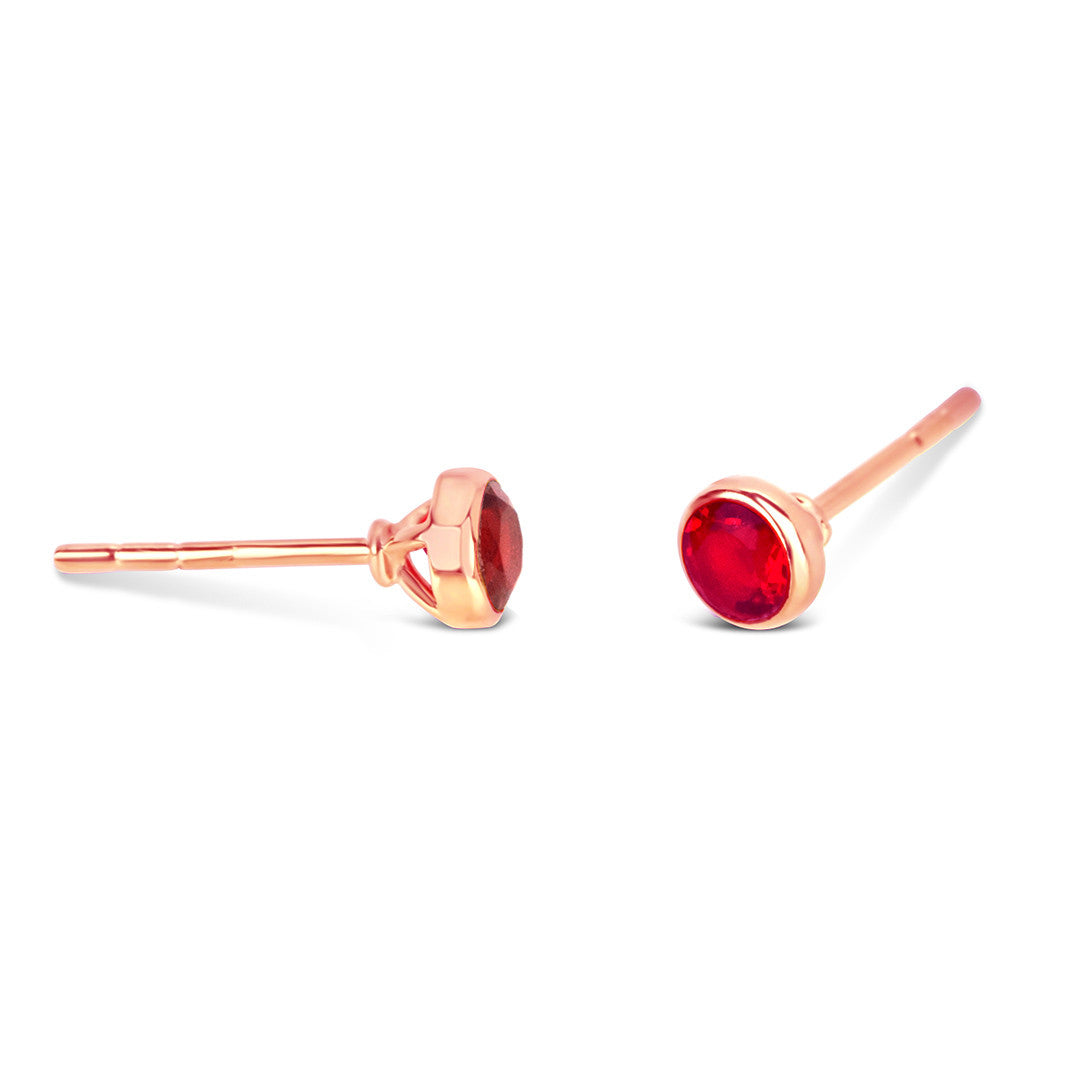 Garnet mini stud earrings in rose gold facing the side on a white background