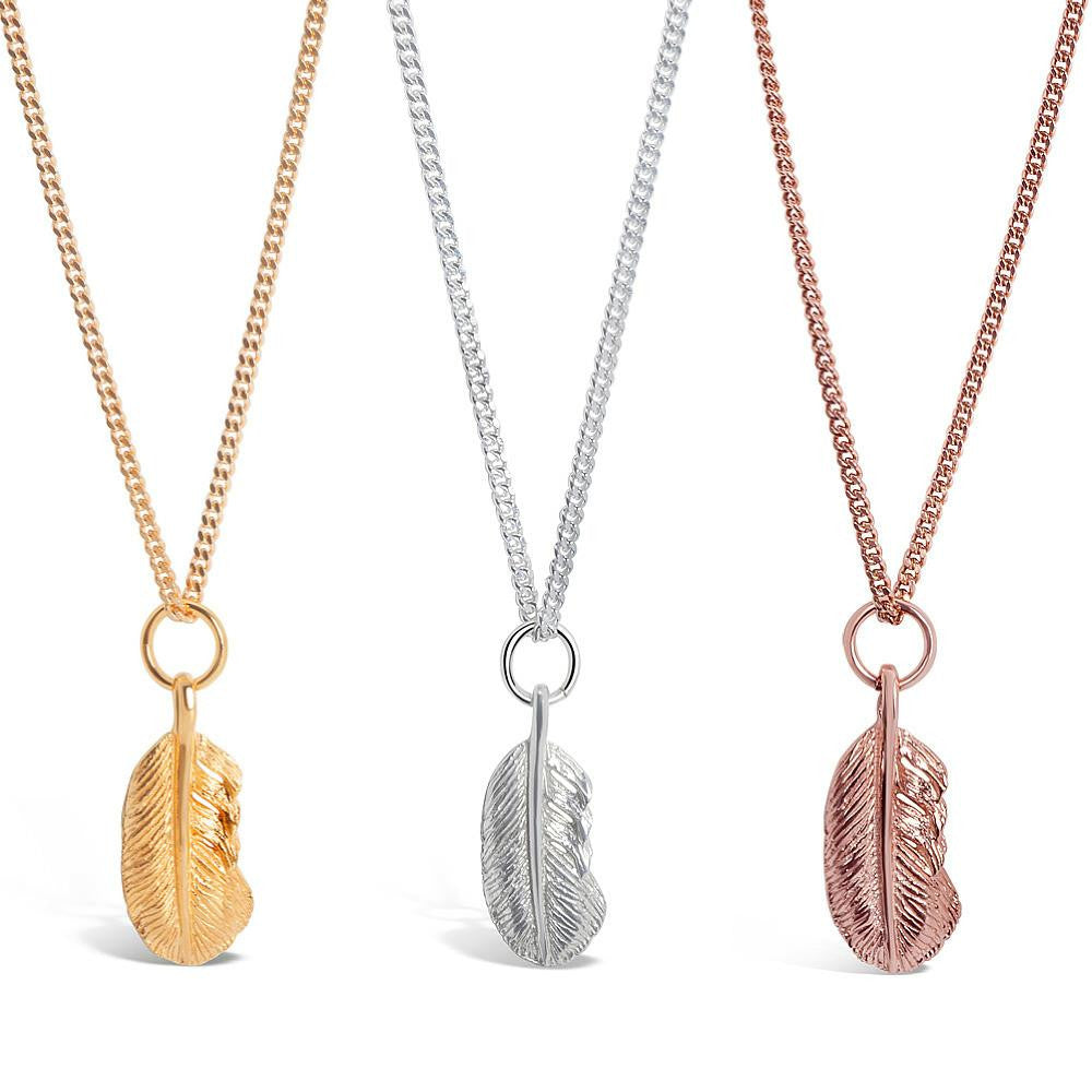 set of three feather pendants in gold, rose gold and silver on a white background