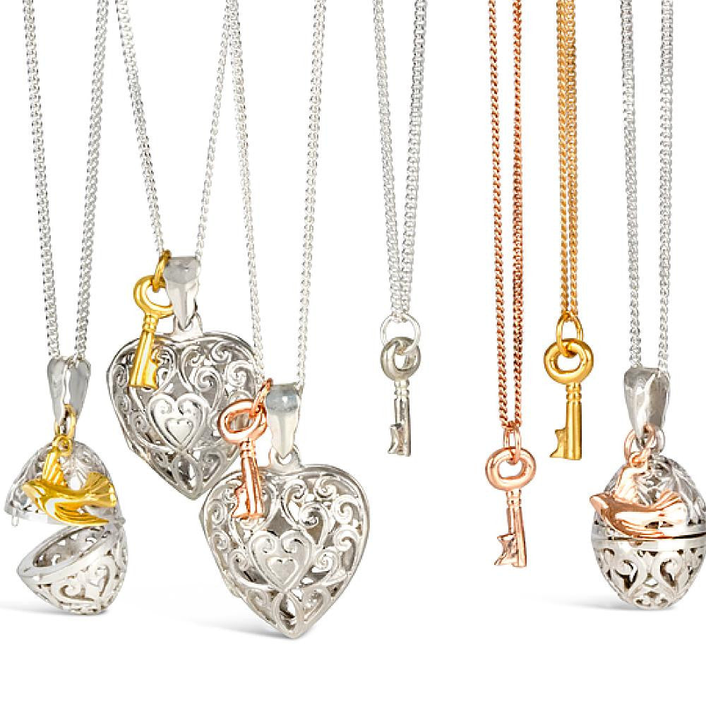 collection of jewellery with bird and key charms attached on a white background