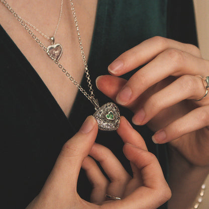 close up of model wearing emerald vintage heart locket in white gold