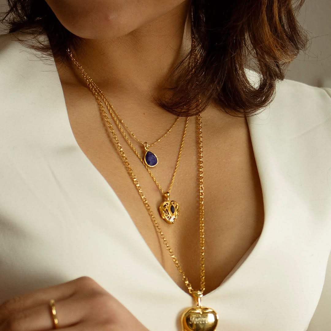 model wearing sapphire heart locket in gold