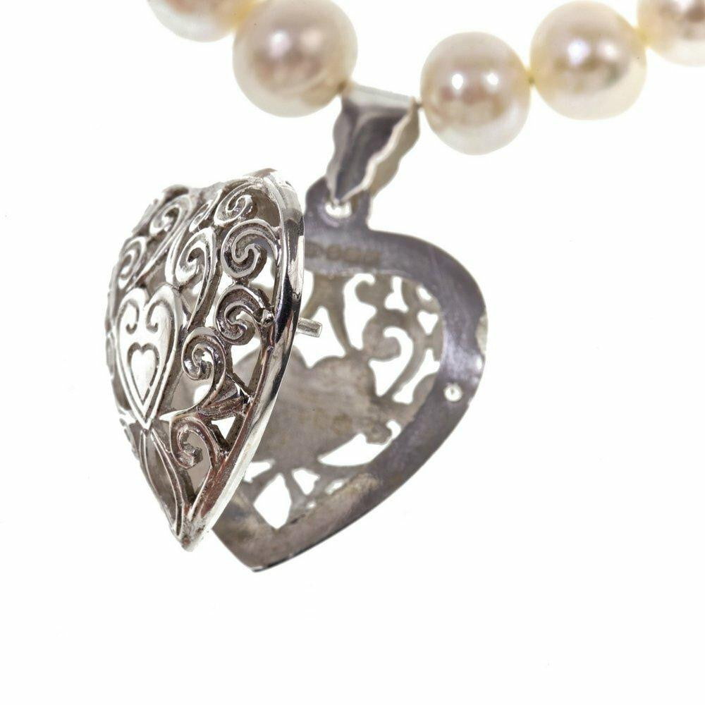 close up of opened keepsake heart necklace in ivory