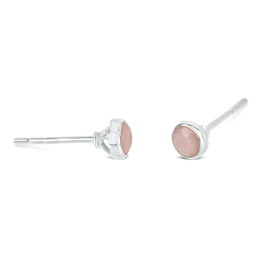 Pink opal stud earrings in silver facing the side on a white background