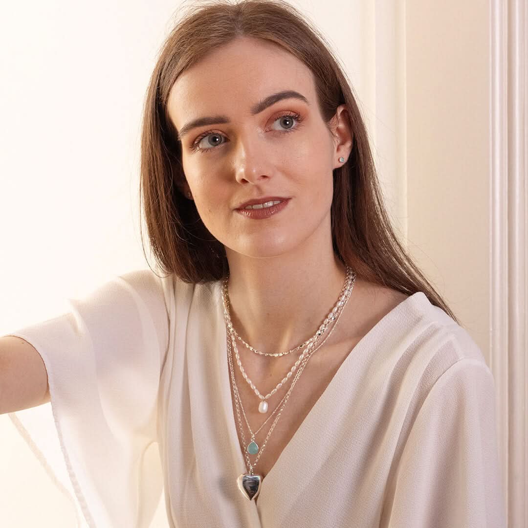 model wearing large two photo heart locket in silver