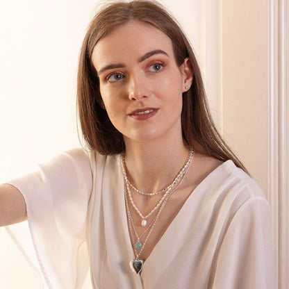 model wearing large two photo heart locket in silver