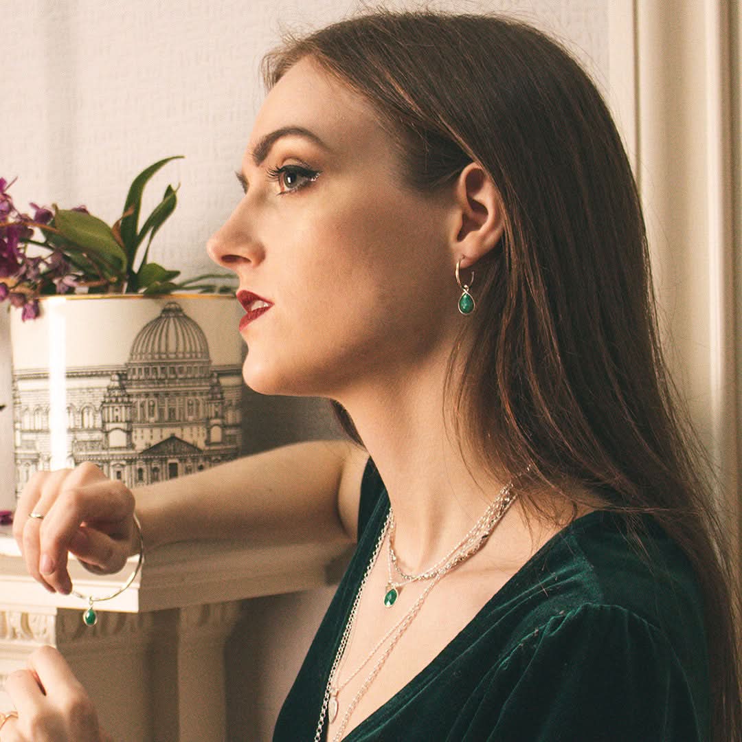 model wearing emerald drop hoop earrings in silver