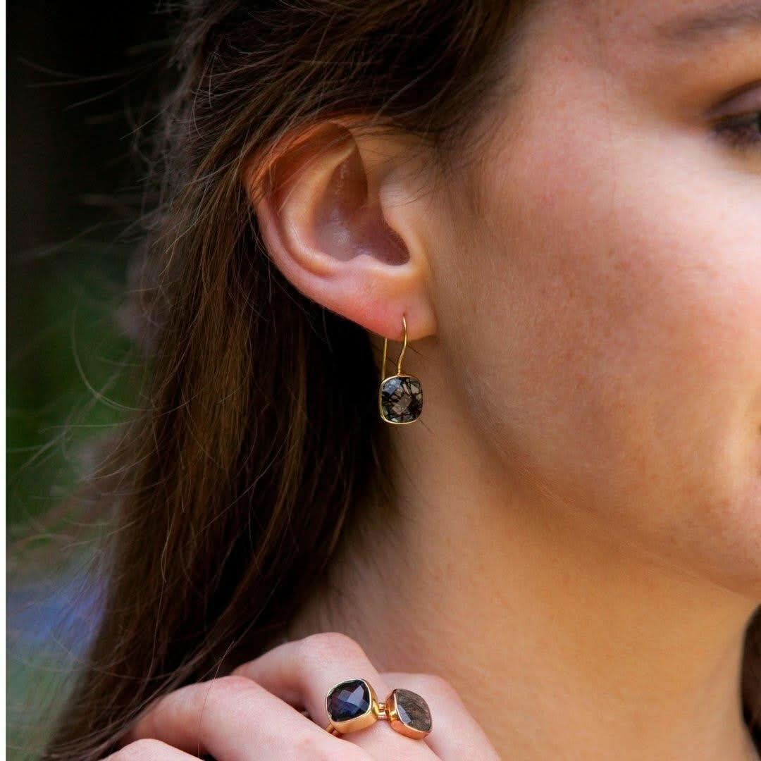 close up of model wearing rutilated quartz cocktail ring in rose gold with matching earrings 