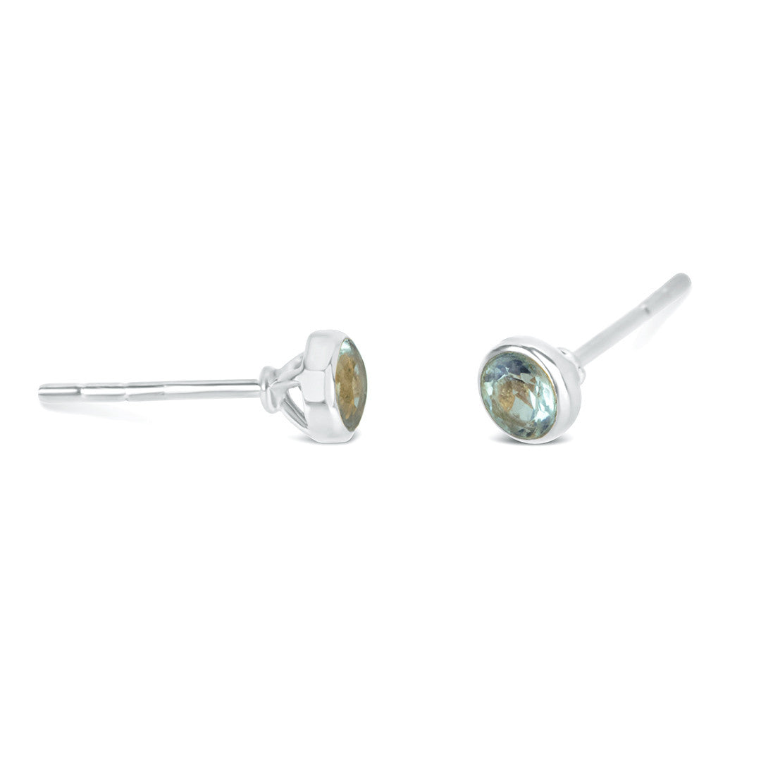 Blue topaz mini stud earrings in silver facing the side on a white background