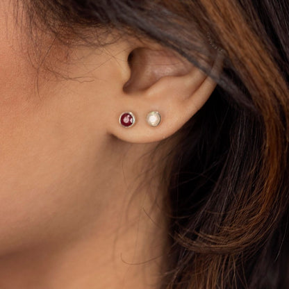Silver moonstone stud earrings and ruby gemstone earrings on a model