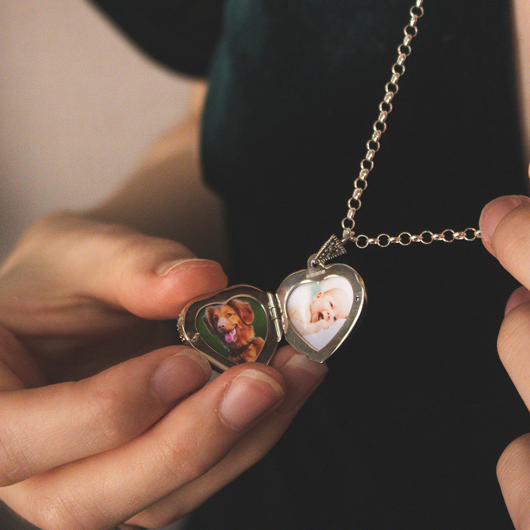 women holding emerald vintage heart locket with family photos inside