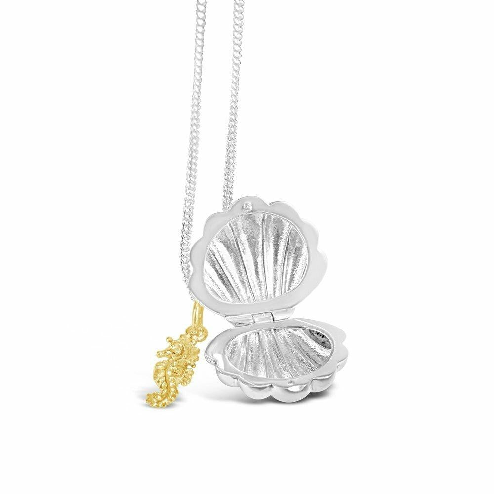 opened seahorse locket in silver with gold seahorse charm on a white background