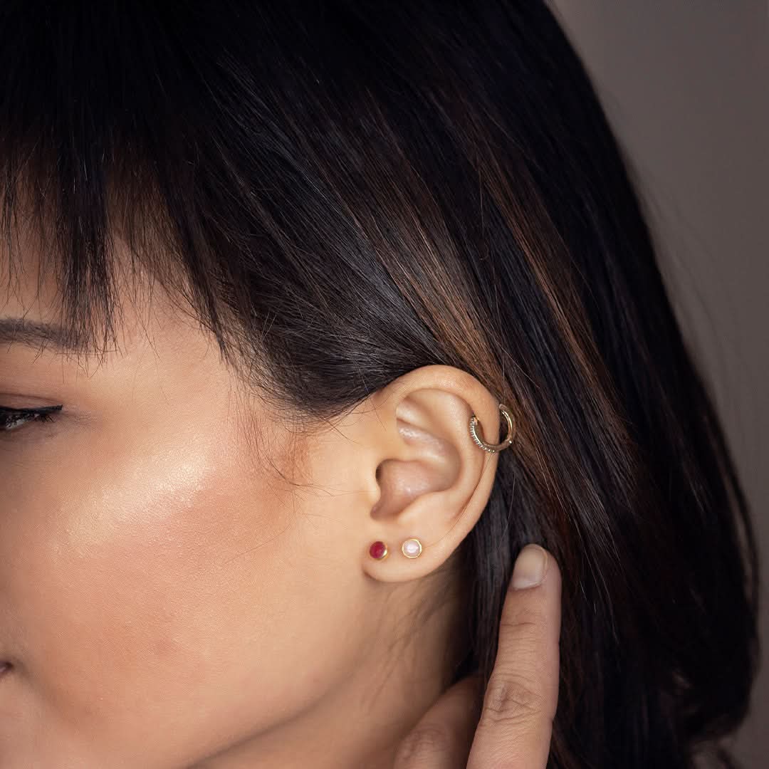 close up of model wearing pink opal mini stud earrings in rose gold