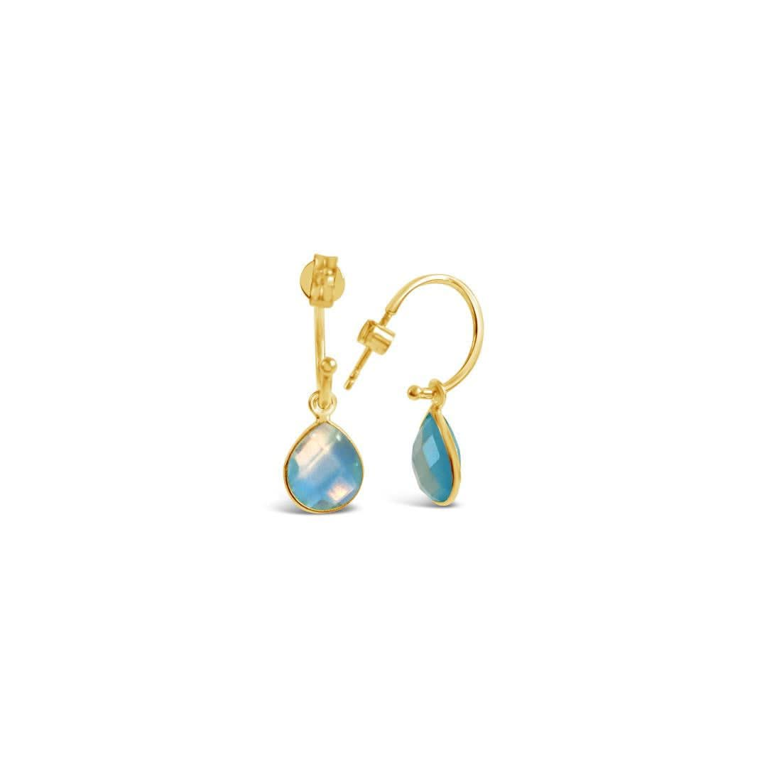 blue topaz drop hoop earrings in gold on a white background