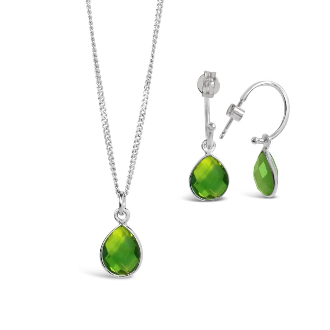 silver peridot charm necklace and matching drop hoop earrings on a white background