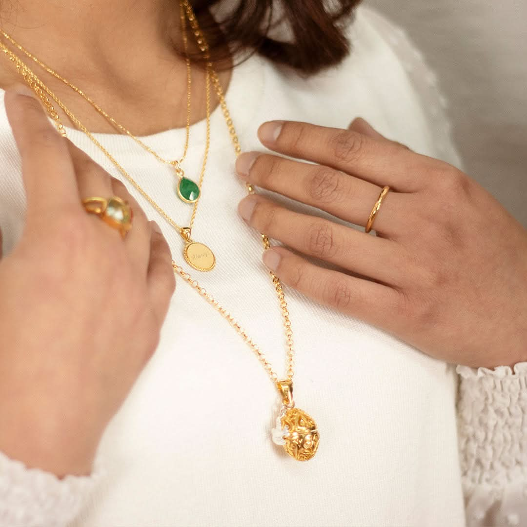 close up of model wearing gold bird locket