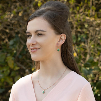 model wearing emerald drop hoop earrings in rose gold