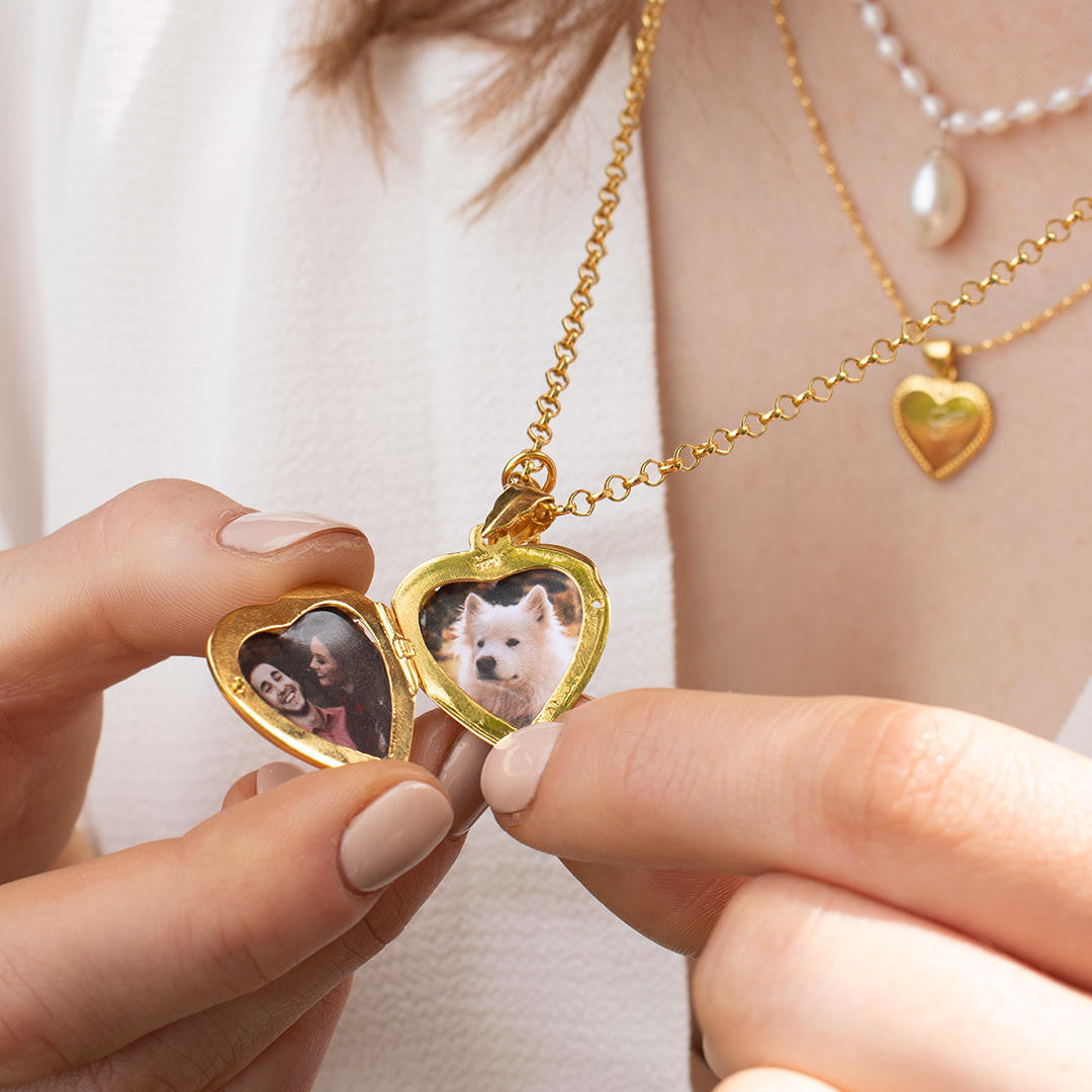 model wearing opened key locket in gold with family photos inside