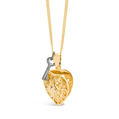key locket in gold with silver key charm attached on a white background