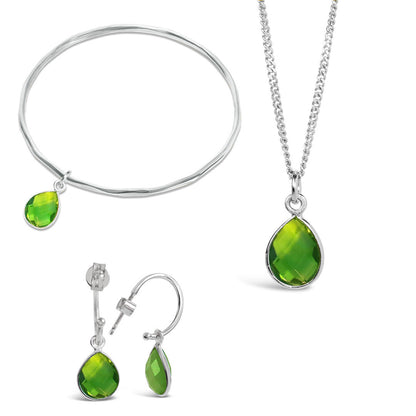 peridot silver charm bangle, necklace and drop hoop earrings on a white background