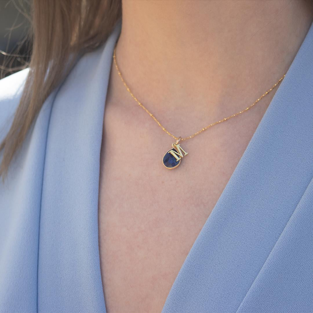 model wearing gold sapphire charm necklace with gold initial charm