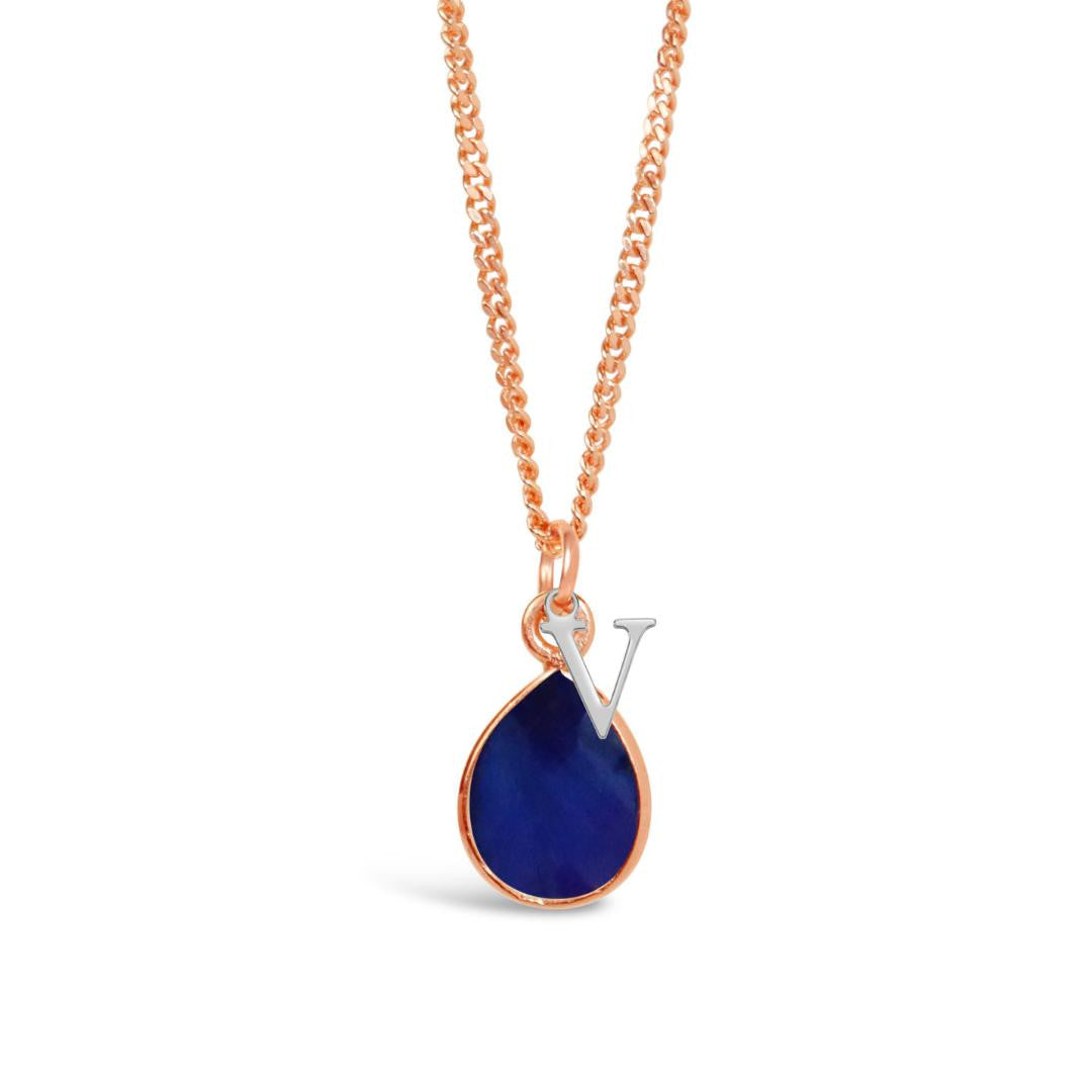 sapphire charm necklace in rose gold with silver initial charm on a white background