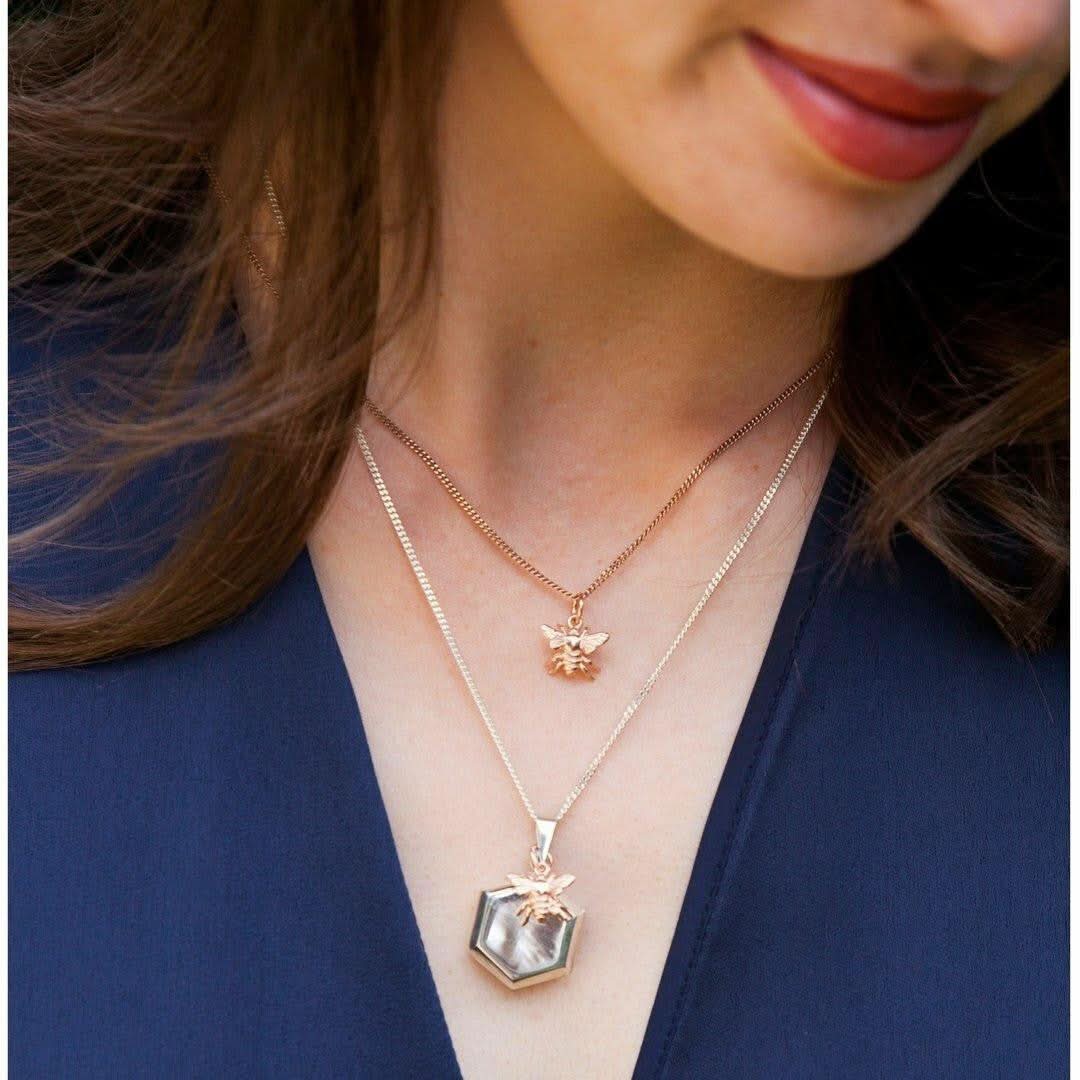 model wearing bee pendant in gold with bee locket