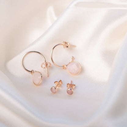 pink opal mini stud earrings with matching hoop earrings in rose gold on a white piece of fabric