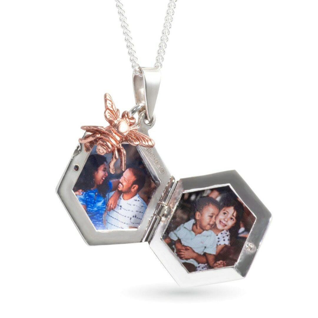 opened bee locket in silver with family photos inside