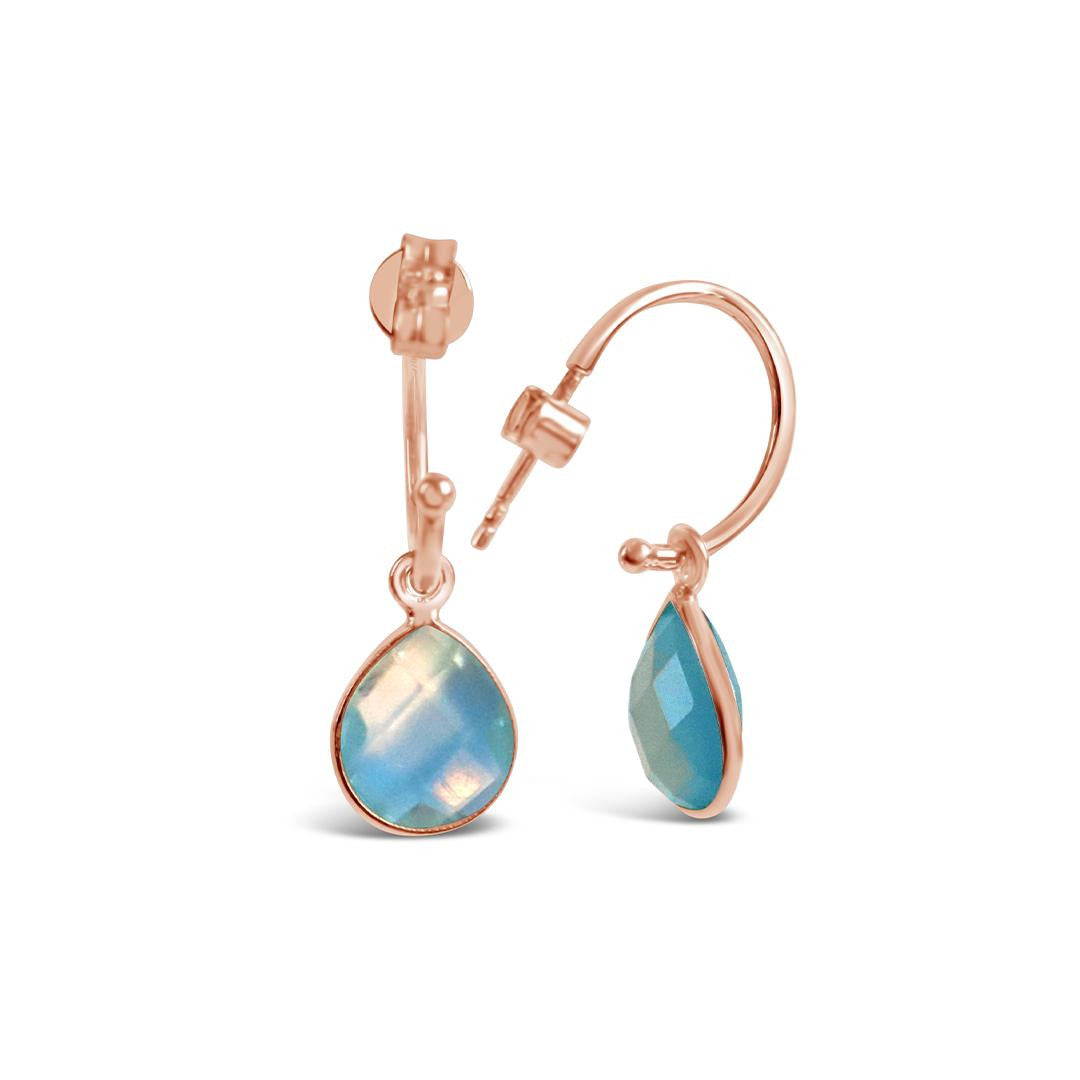 blue topaz drop hoop earrings in rose gold on a white background