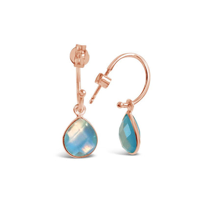 blue topaz drop hoop earrings in rose gold on a white background