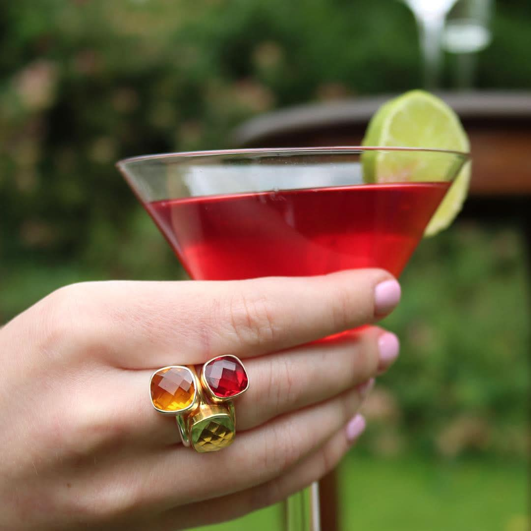 close up of model wearing three cocktail rings in gold