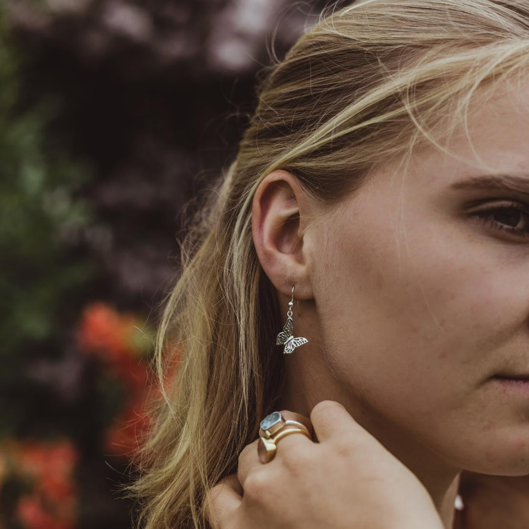 model wearing silver butterfly earrings 