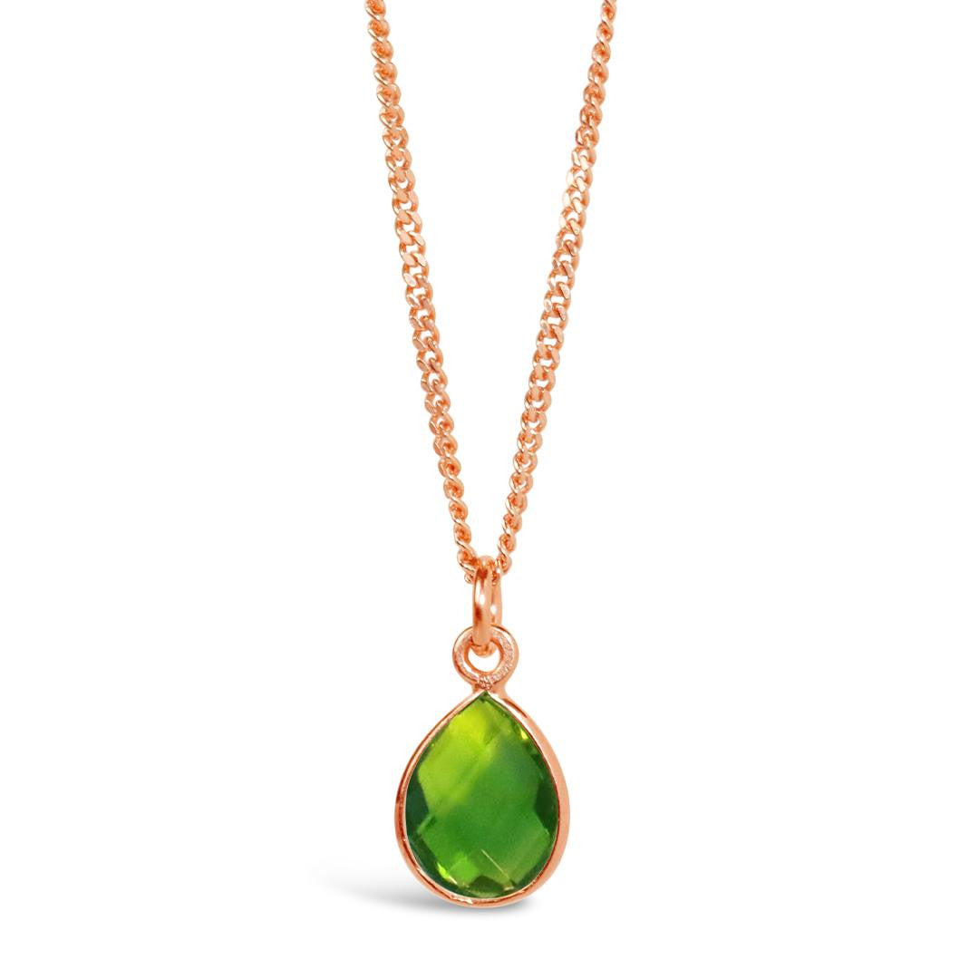peridot charm necklace in rose gold on a white background