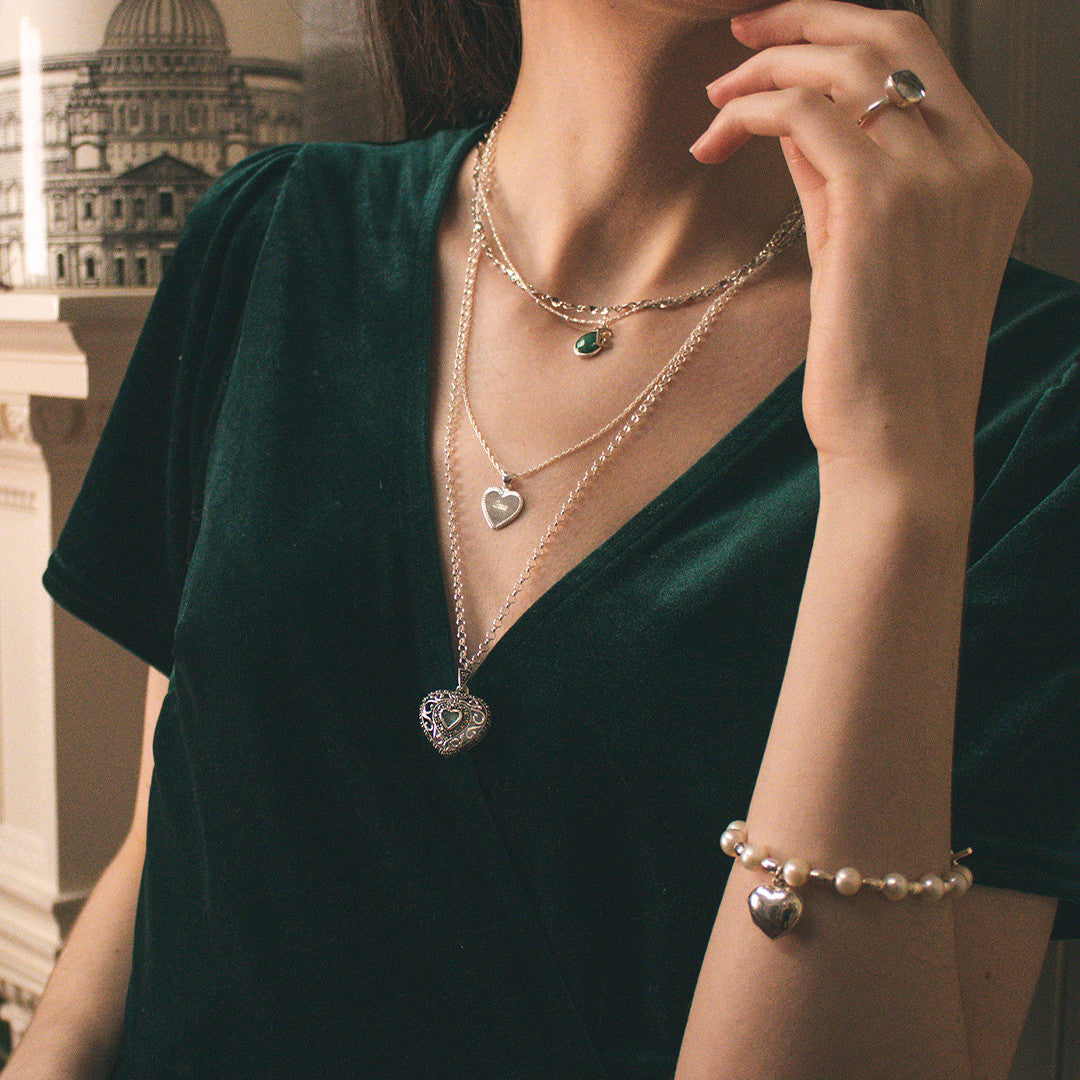 model wearing emerald vintage heart locket in white gold