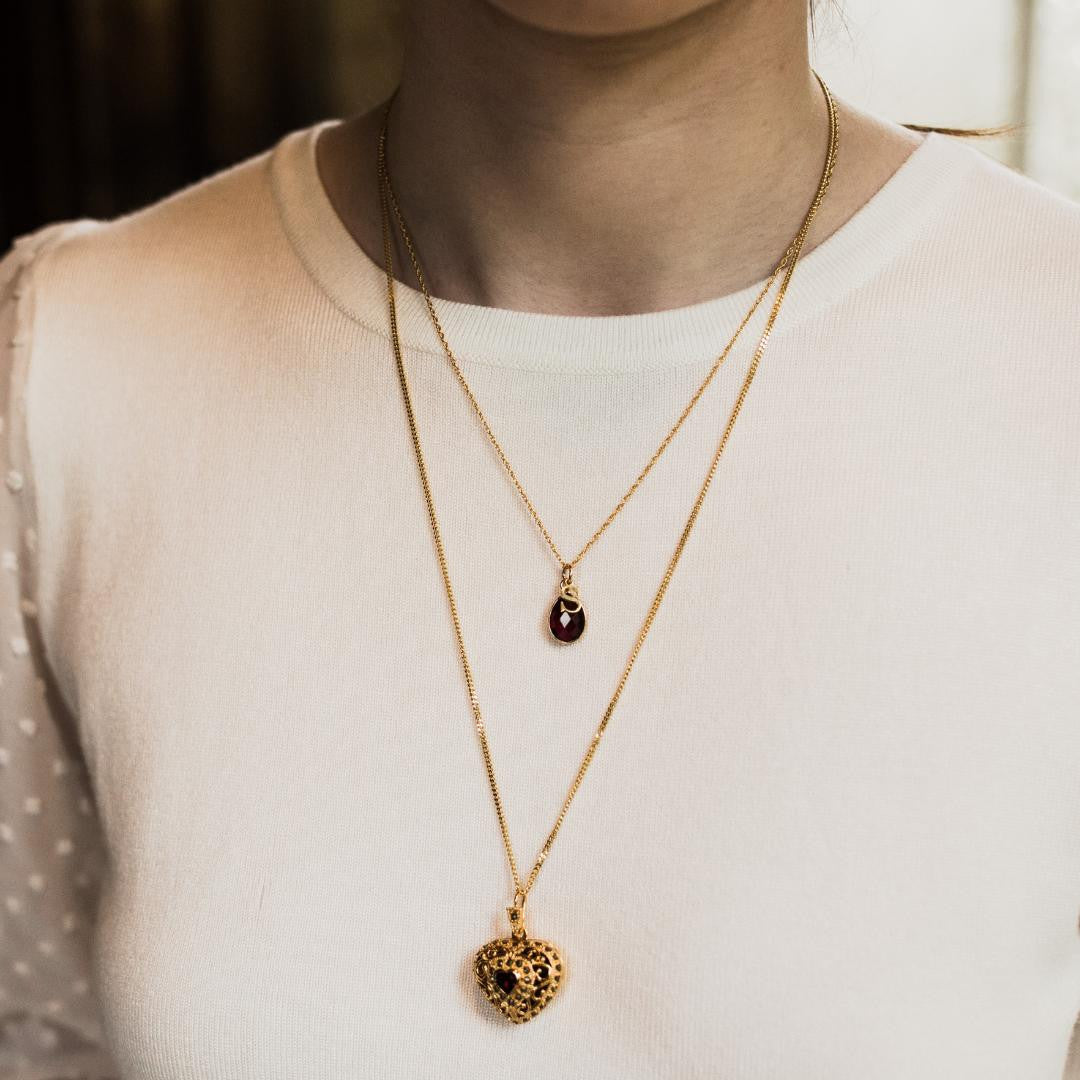 model wearing garnet charm necklace in rose gold