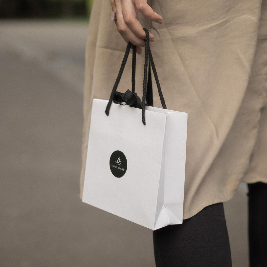 model holding white gift bag by lily blanche