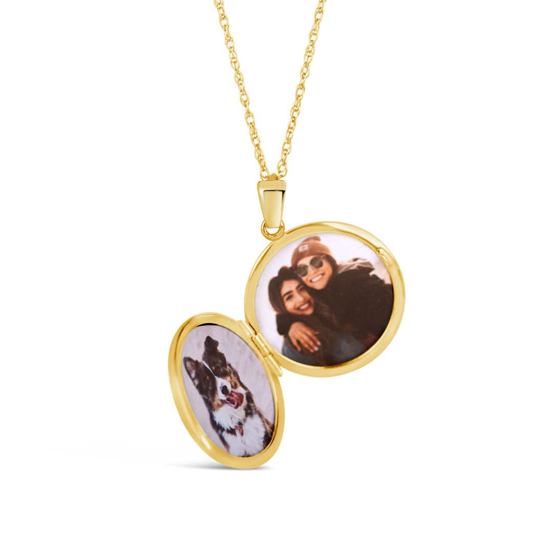 opened gold round diamond locket with family photos