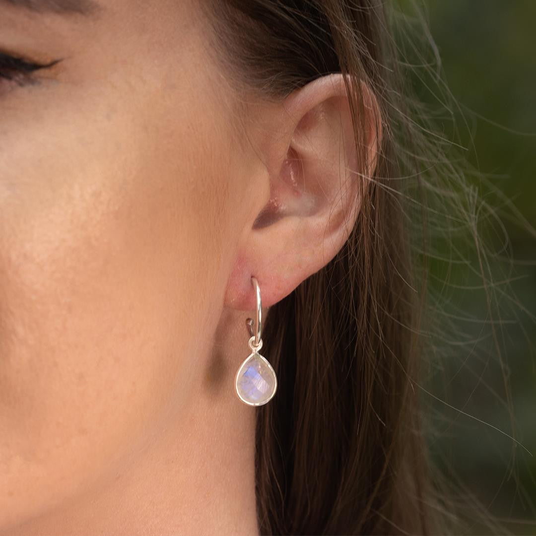 close up of model wearing silver moonstone drop hoop earrings 