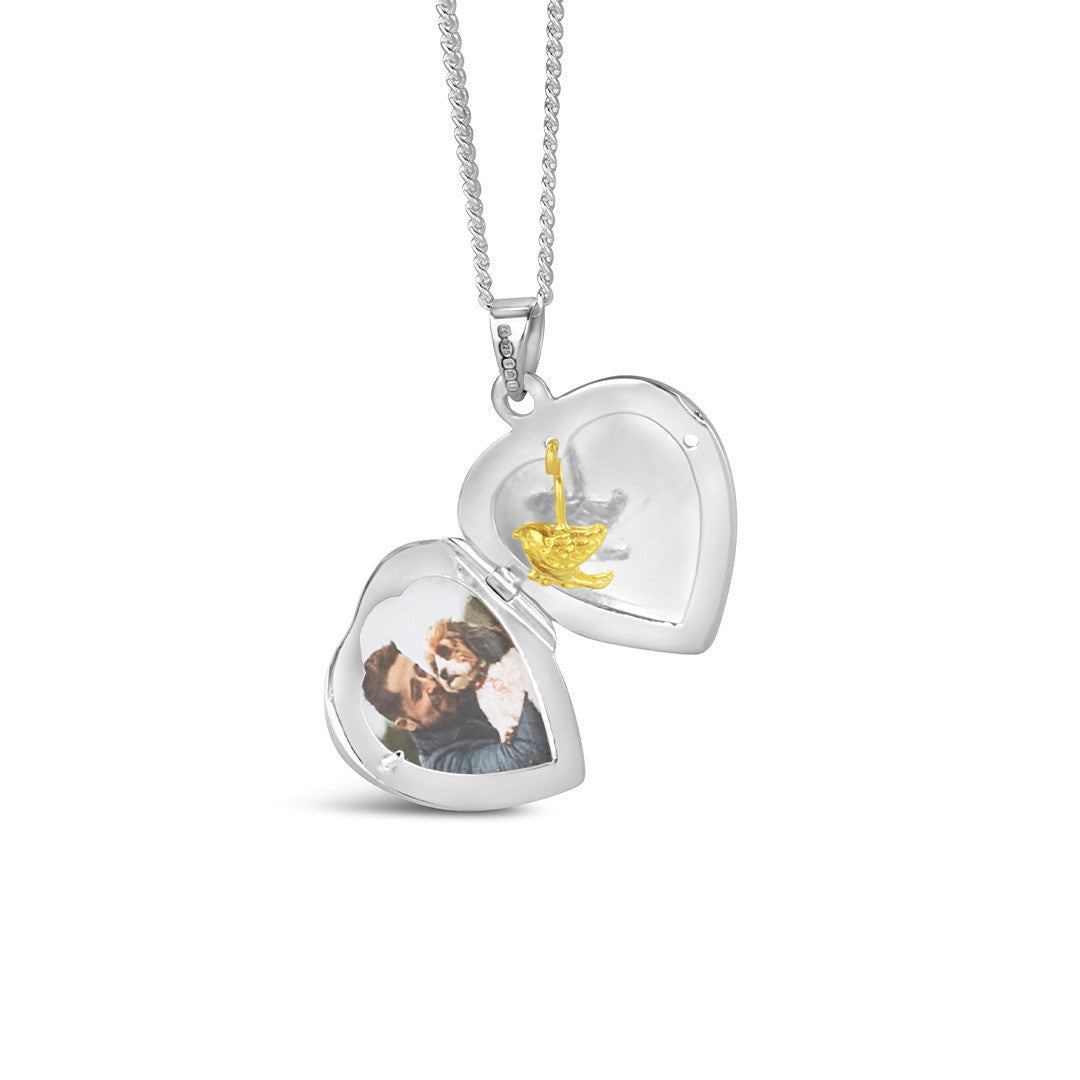 opened secret silver heart locket with gold bird and photo inside