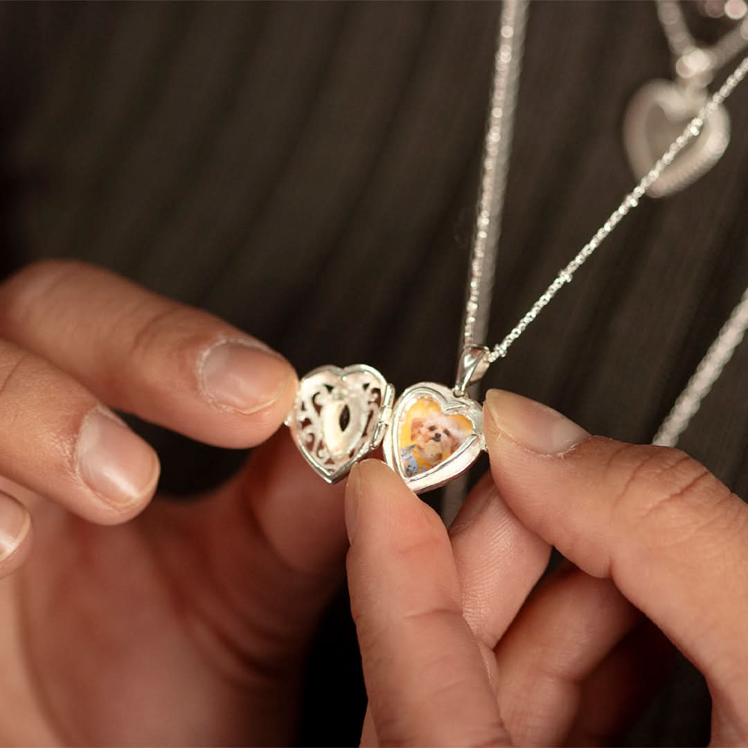 closeup of model wearing opened sapphire heart locket in silver with photo inside