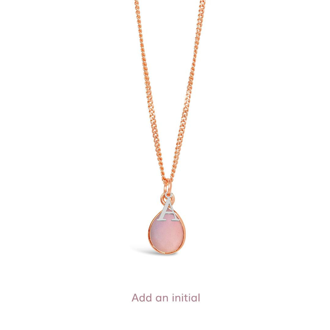 pink opal charm necklace in rose gold with silver initial charm attached on a white background