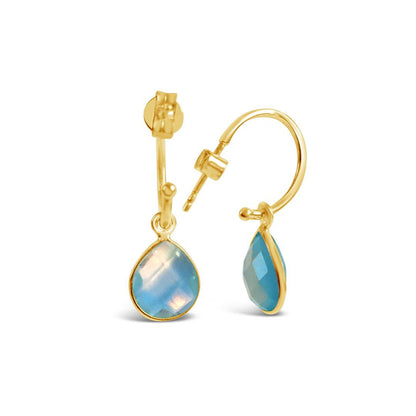 blue topaz drop hoop earrings in gold on a white background