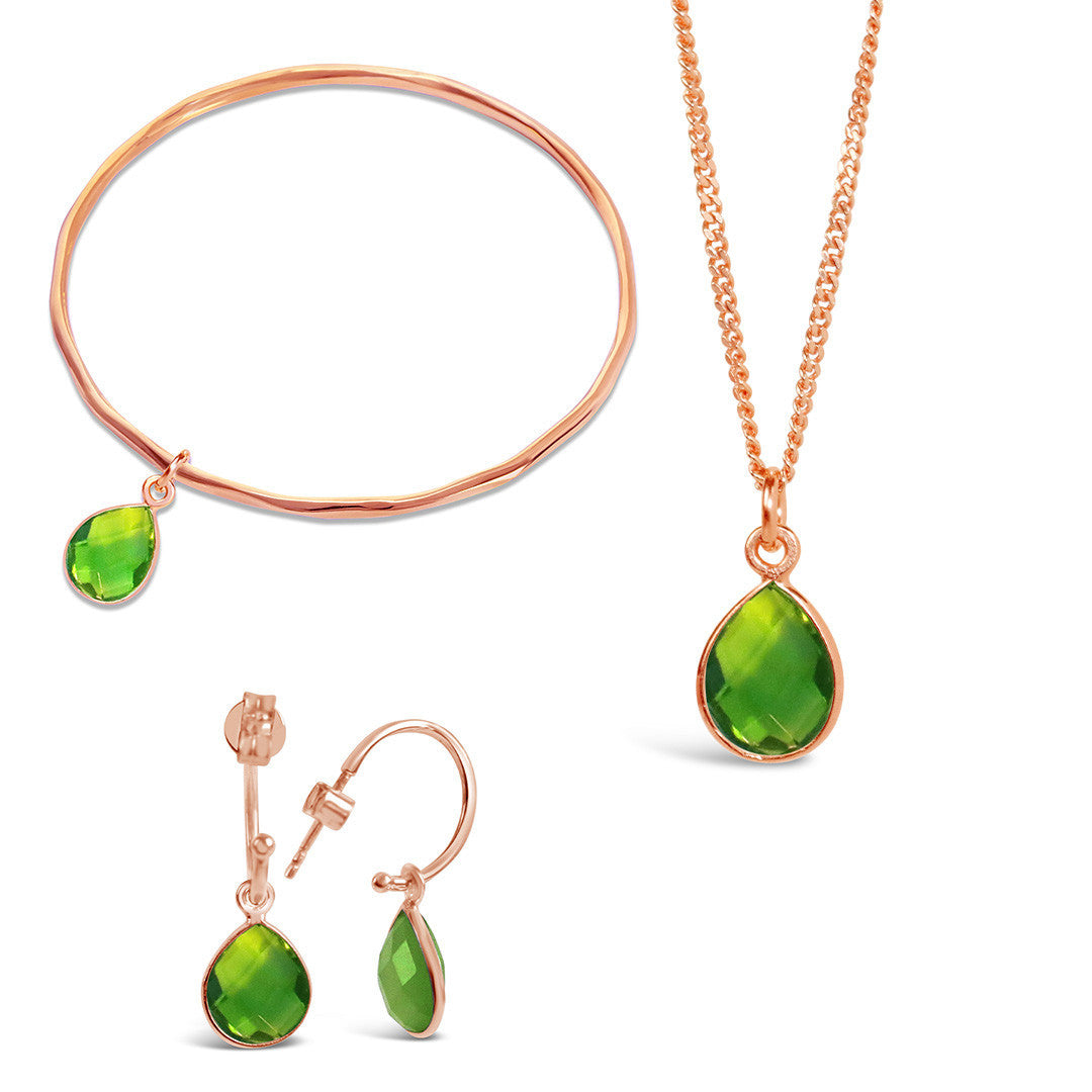 real green peridot teardrop gemstone on a rose gold  thin bangle with matching peridot necklace on gold chain and matching peridot hoop earrings