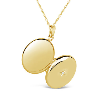 opened oval diamond locket in gold on a white background