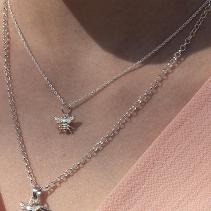 close-up of model wearing white gold rope chain with bee pendant