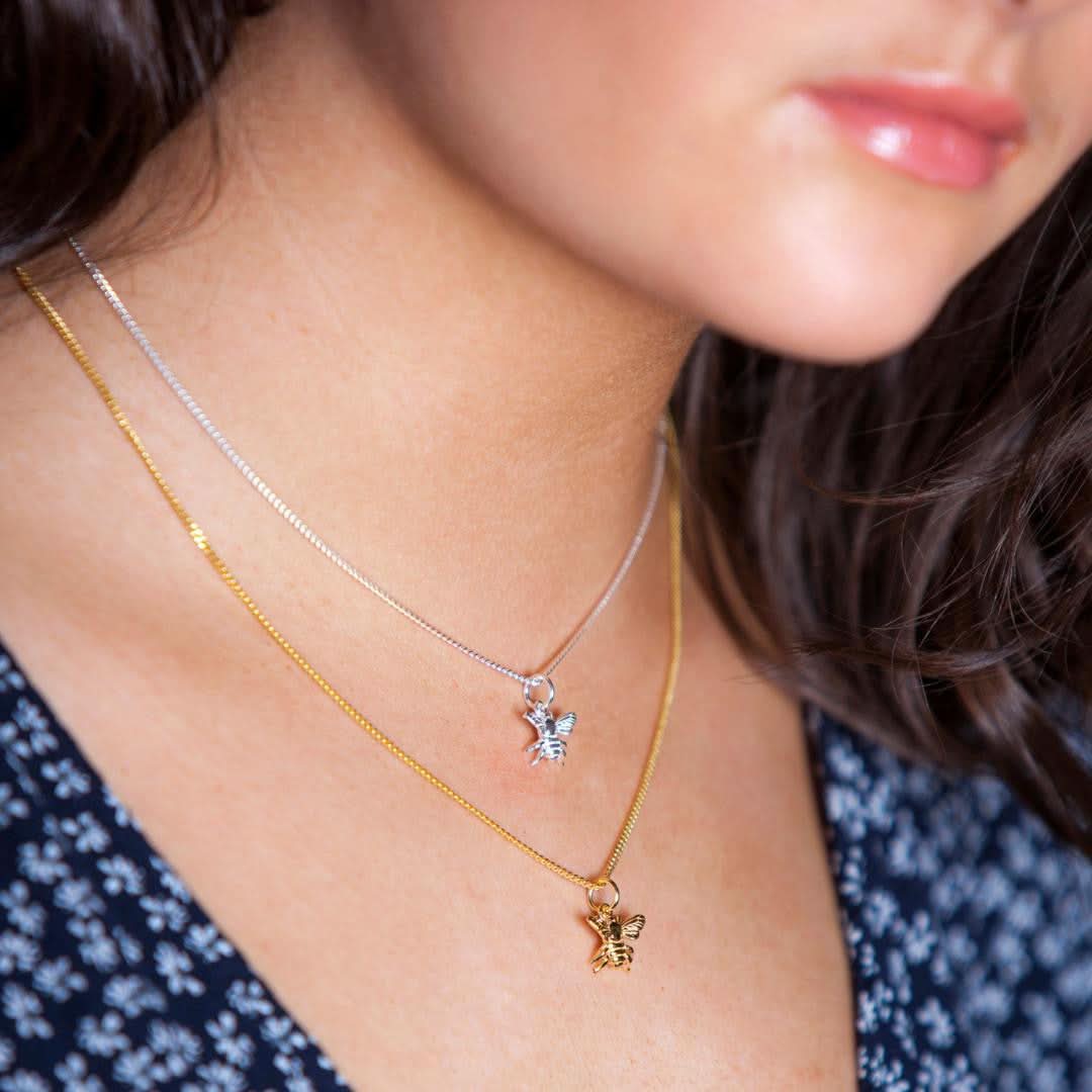 close up of model wearing silver bee pendant 
